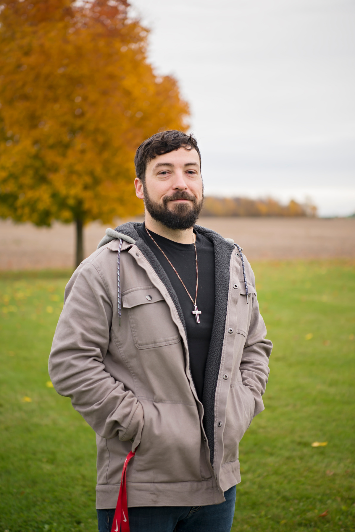 man with black shirt and tree in background