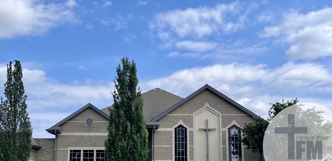 church building with fluffy white clouds and trees