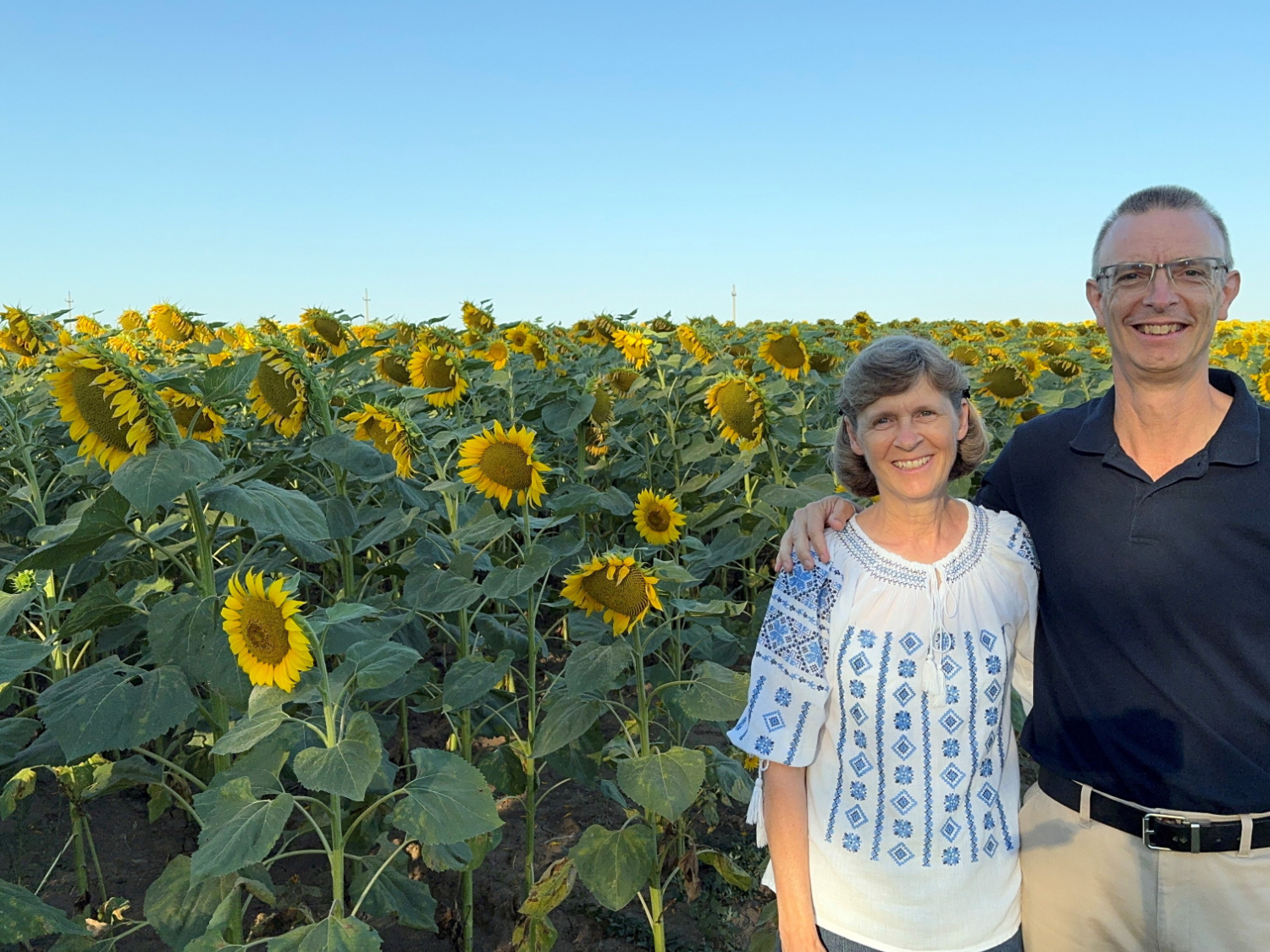 couple standing in front of sunflower field