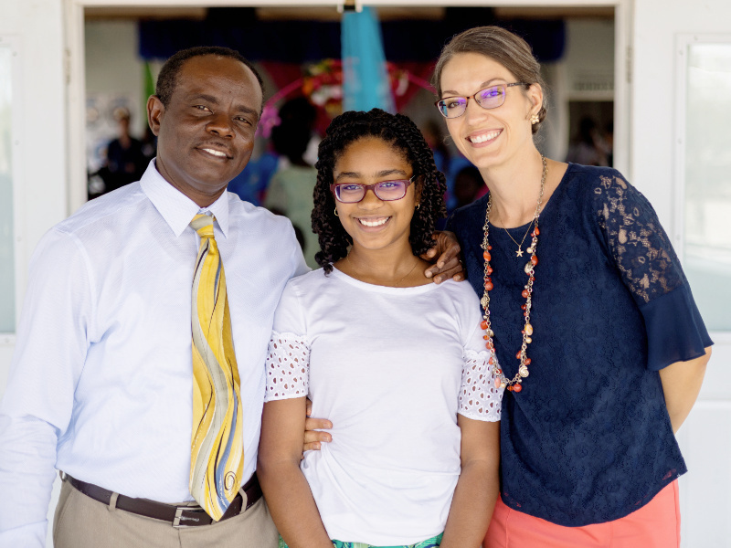 woman with dark hair and glasses man with white shirt and yellow tie young girl with glasses