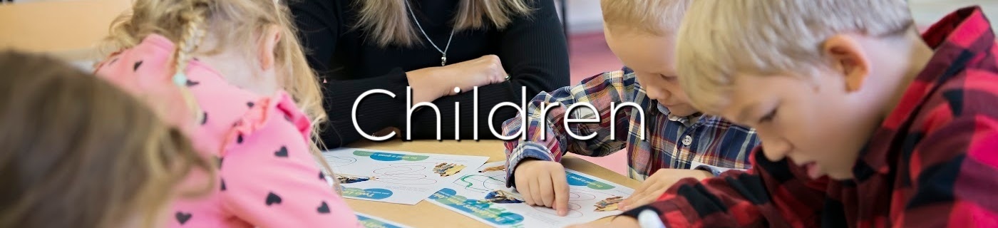 Group of children colouring at a table, white lettering